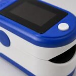 FO-POX-001 pulse oximeter clipped on a fingertip during measurement